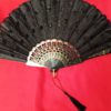 gothic black sequined victorian wedding fan with tassel red background